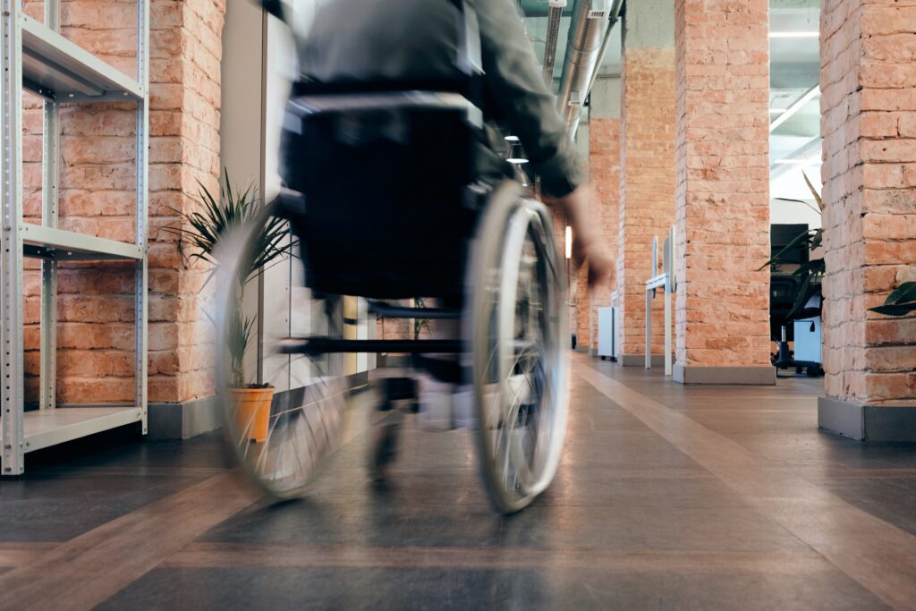 person in wheelchair headed down a hallway